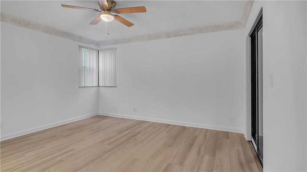 5681 Riverside Drive, Unit 101A6 Coral Springs, FL 33067 - Photo 11 of 24 wooden floor in an empty room with a window