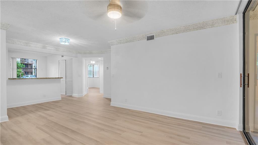 5681 Riverside Drive, Unit 101A6 Coral Springs, FL 33067 - Photo 6 of 24 a view of an empty room with wooden floor