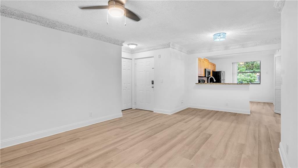 5681 Riverside Drive, Unit 101A6 Coral Springs, FL 33067 - Photo 7 of 24 wooden floor in an empty room with a window