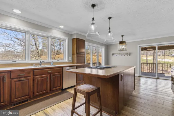 a kitchen with stainless steel appliances granite countertop wooden floor window and cabinets