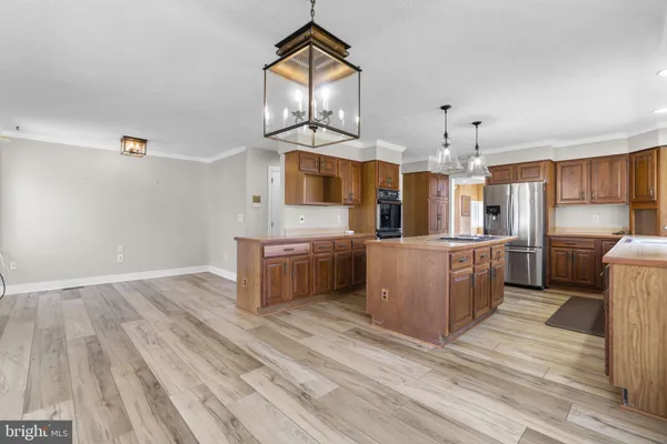 a large kitchen with stainless steel appliances a large counter top and a stove