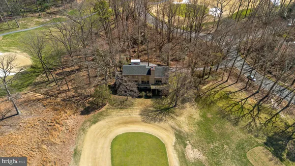 a aerial view of a house with a swimming pool and large trees
