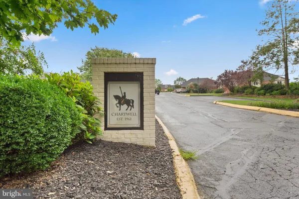 a sign that is sitting in front of a tree