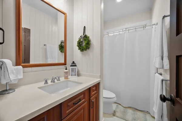 a bathroom with a granite countertop sink toilet and shower