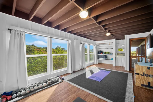 a wooden floor with lots of furniture and a large window