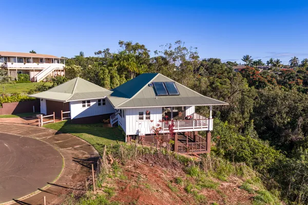 a front view of a house with yard and trees