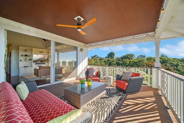 a living room with furniture a rug and a floor to ceiling window