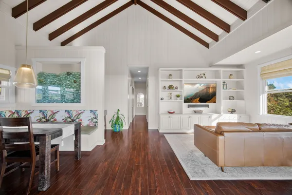 a large living room with a large window wooden floor and furniture