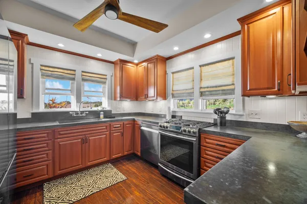 a kitchen with stainless steel appliances granite countertop wooden cabinets a sink and a stove