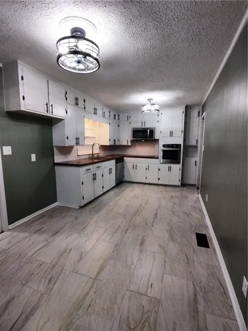 a large kitchen with a wooden floor and stainless steel appliances