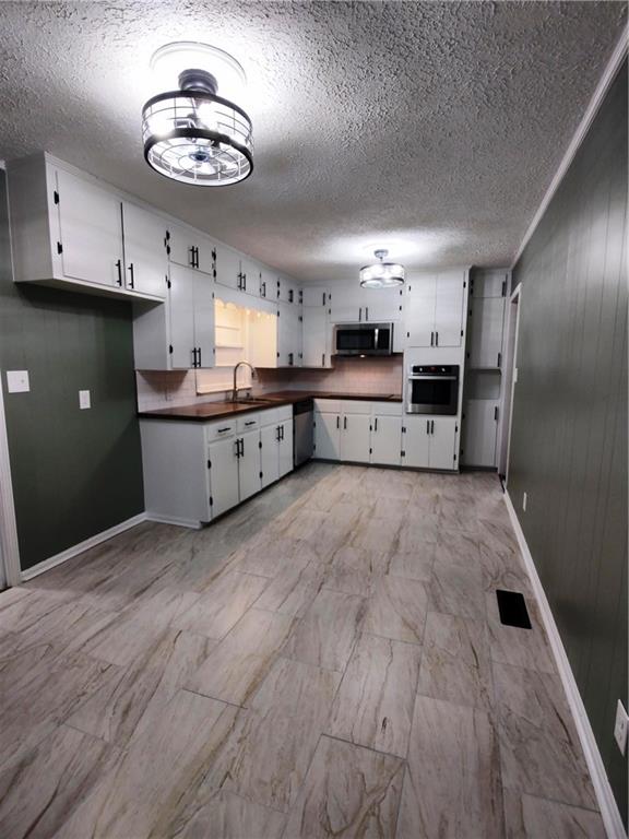 907 Gadsden Road Southwest Cave Spring, GA 30124 - Photo 5 of 26 a large kitchen with a wooden floor and stainless steel appliances