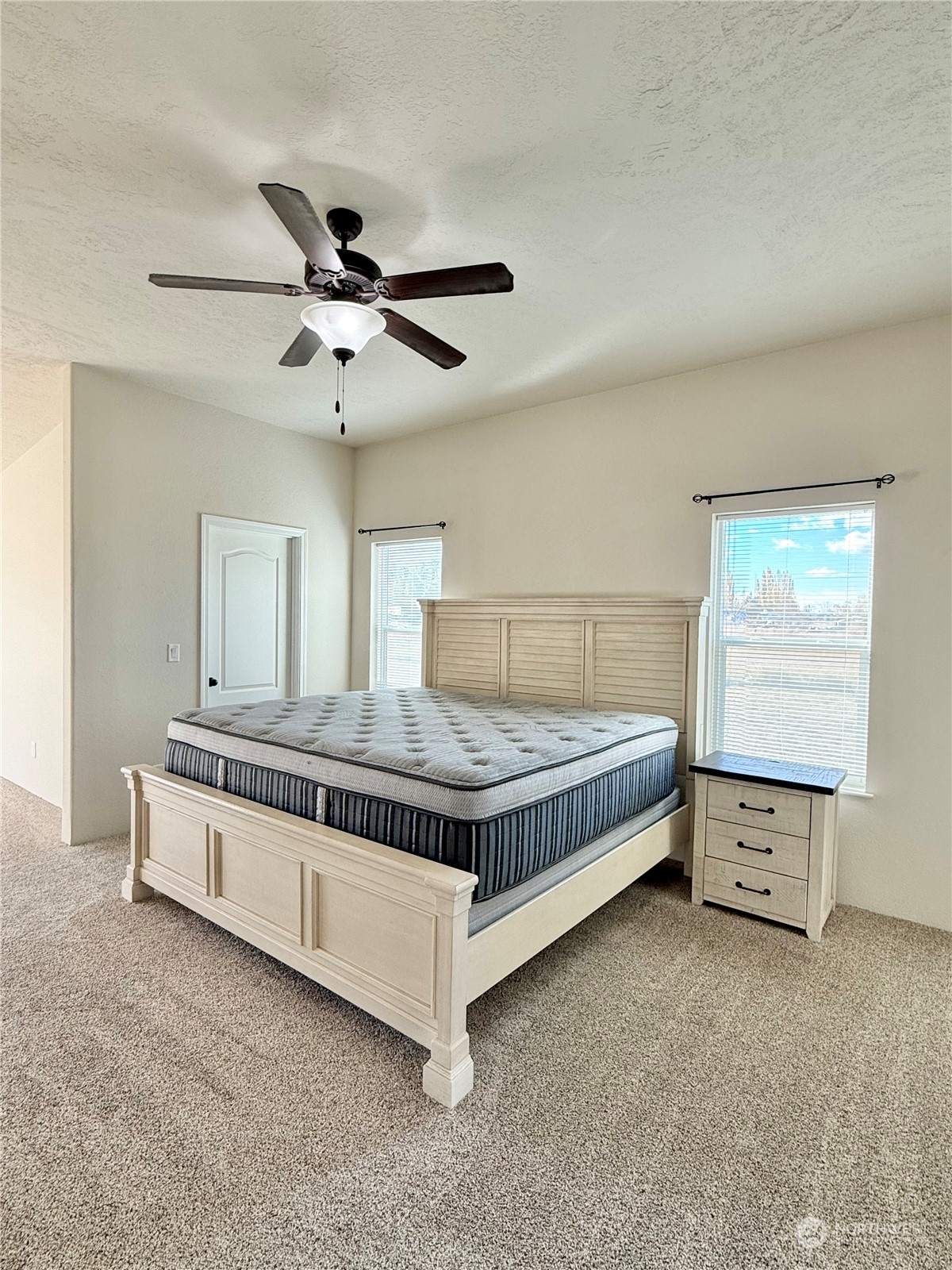 18 Root Road Okanogan, WA 98840 - Photo 21 of 36 a spacious bedroom with a bed and a ceiling fan