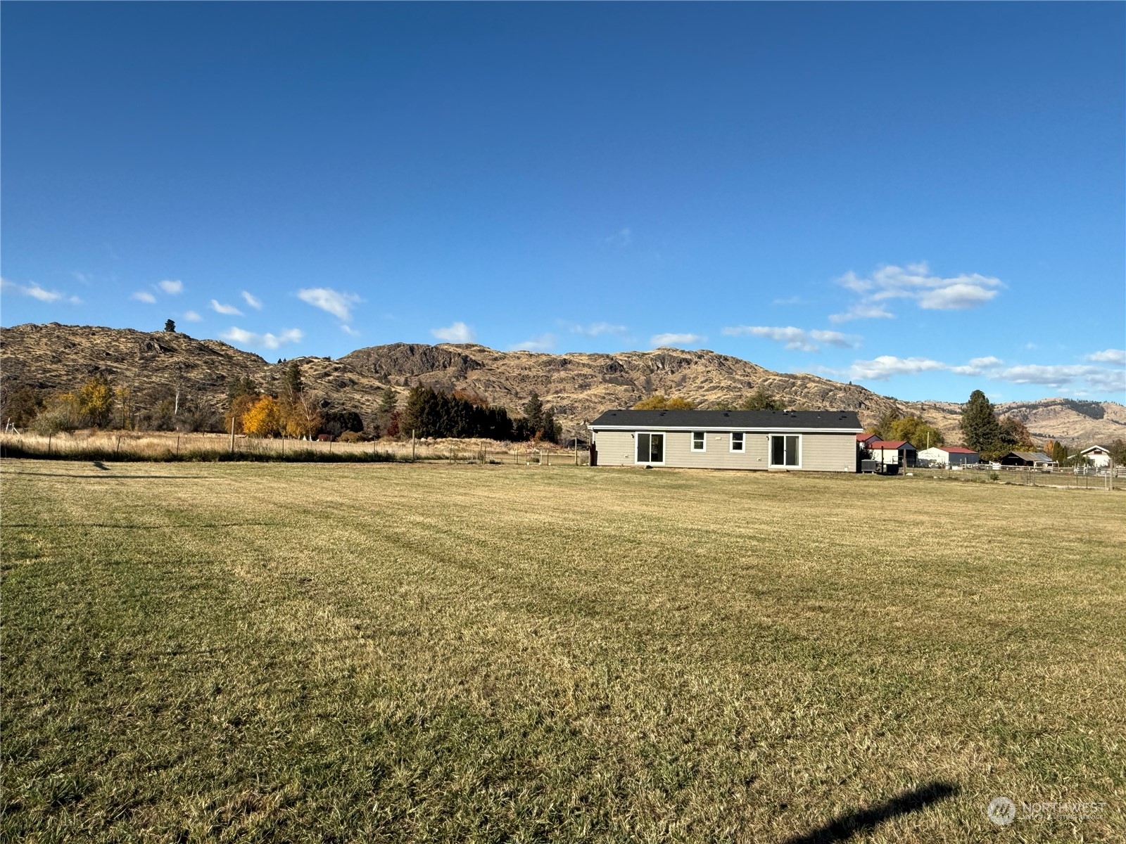 18 Root Road Okanogan, WA 98840 - Photo 31 of 36 a view of a big yard next to a building