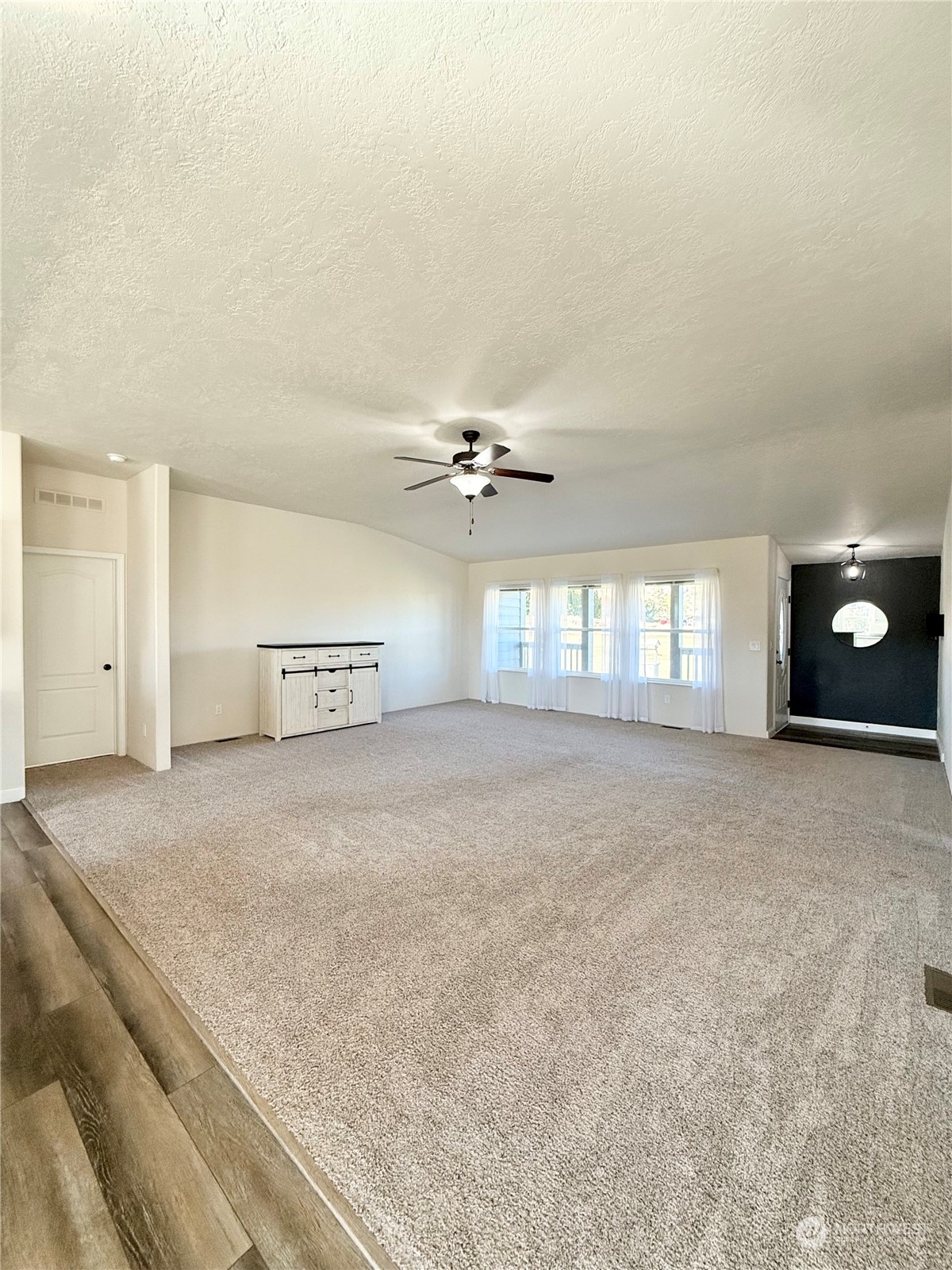 18 Root Road Okanogan, WA 98840 - Photo 4 of 36 an empty room with chandelier fan and windows