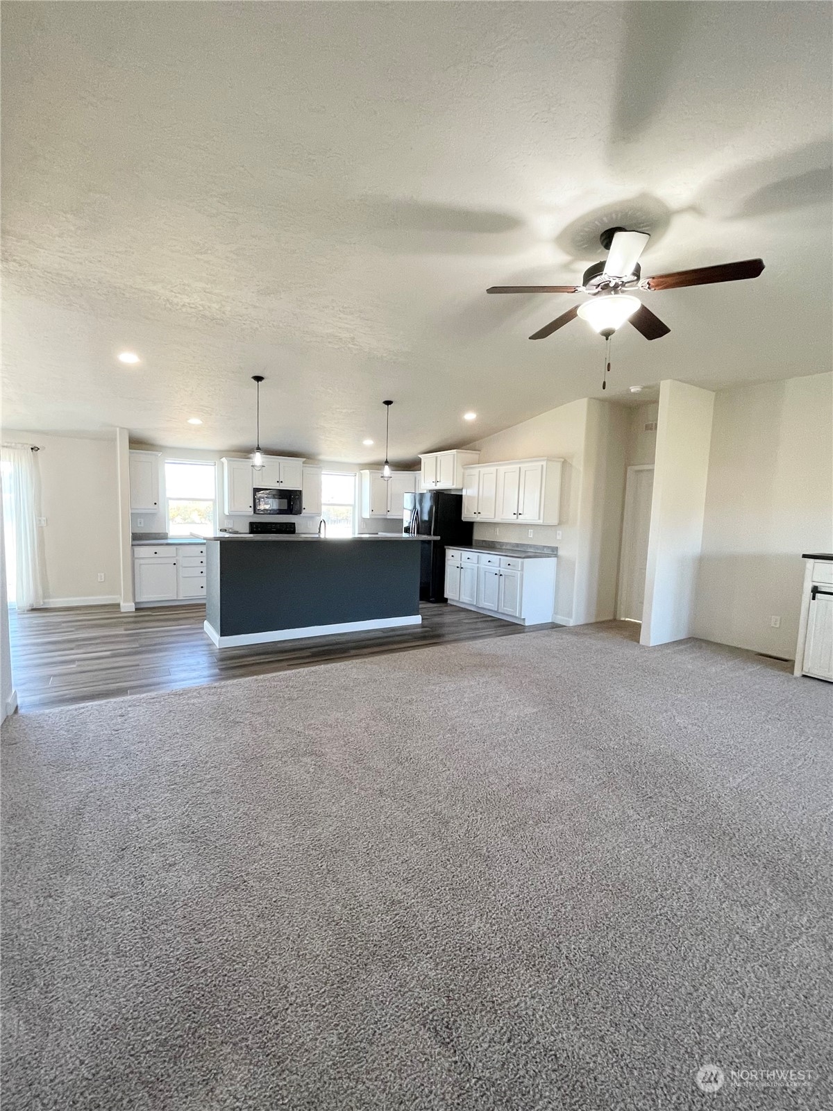 18 Root Road Okanogan, WA 98840 - Photo 7 of 36 a view of a kitchen with a stove cabinets a ceiling fan and wooden floor