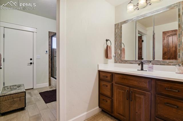 12810 Holmes Road Colorado Springs, CO 80908 - Photo 30 of 45 Bathroom featuring vanity and bath / shower combo with glass door in Lower Level, Extra Laundry Hookups in the Lower Level