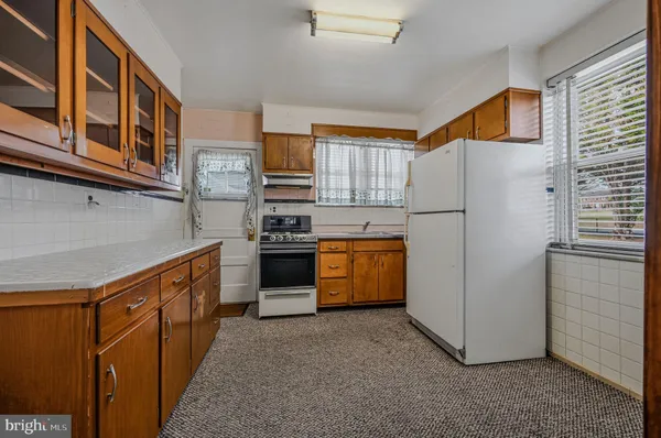 a kitchen with stainless steel appliances granite countertop a refrigerator a stove a sink and a microwave