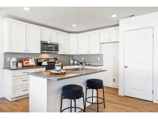 a kitchen with granite countertop a sink stove and cabinets