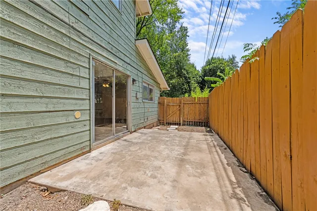 a view of backyard with small cabin and wooden fencing