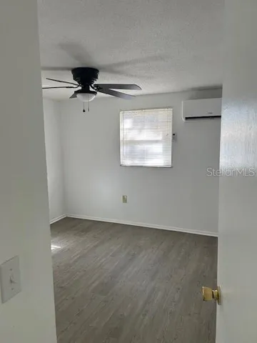 an empty room with a ceiling fan and a window