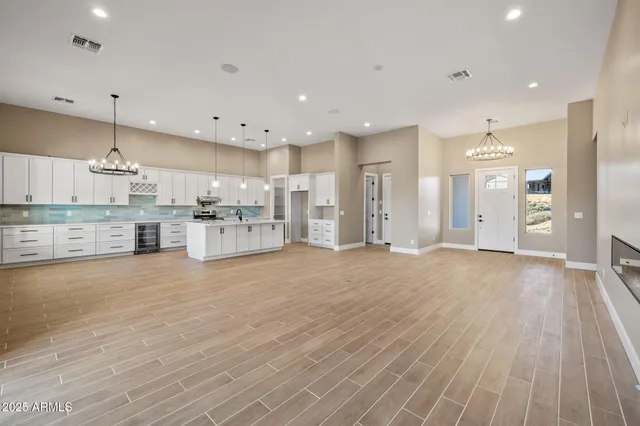 a view of a hallway with wooden floor and a chandelier