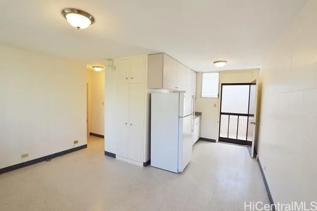 an empty room with a cabinet and mirrors