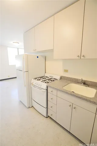 a kitchen with a sink stove and white cabinets