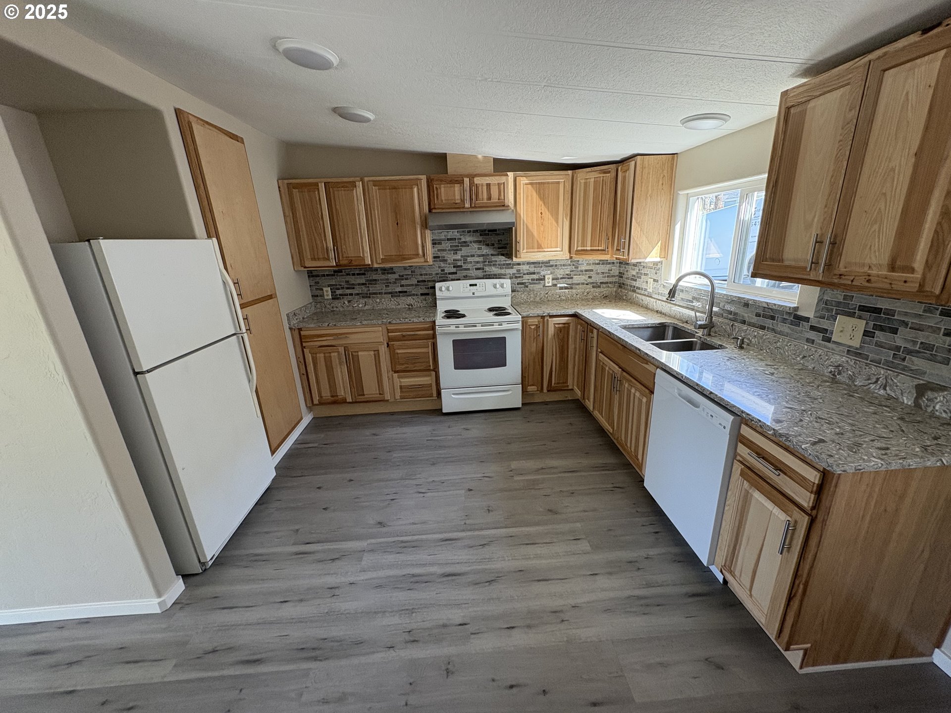 605 South 2nd Street Springfield, OR 97477 - Photo 8 of 20 a kitchen with a sink a refrigerator a stove top oven and wooden floor