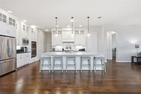 a large white kitchen with lots of counter space and stainless steel appliances