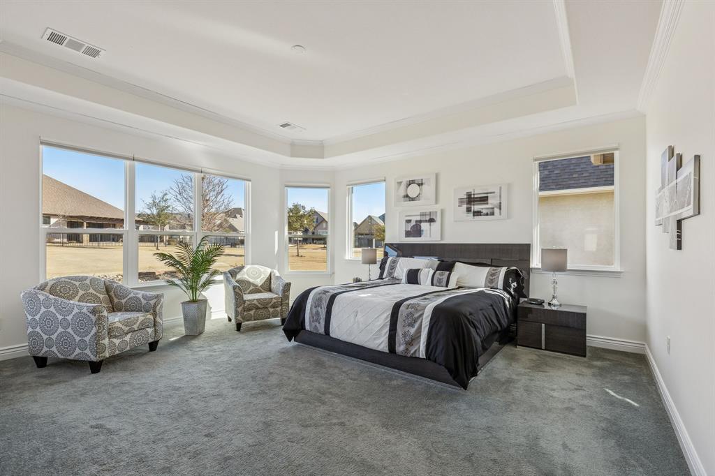 8717 Basanite Avenue Denton, TX 76207 - Photo 15 of 30 a spacious bedroom with a bed and a couch