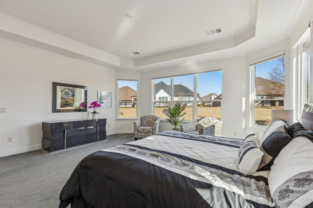 8717 Basanite Avenue Denton, TX 76207 - Photo 16 of 30 a spacious bedroom with a bed and wooden floor