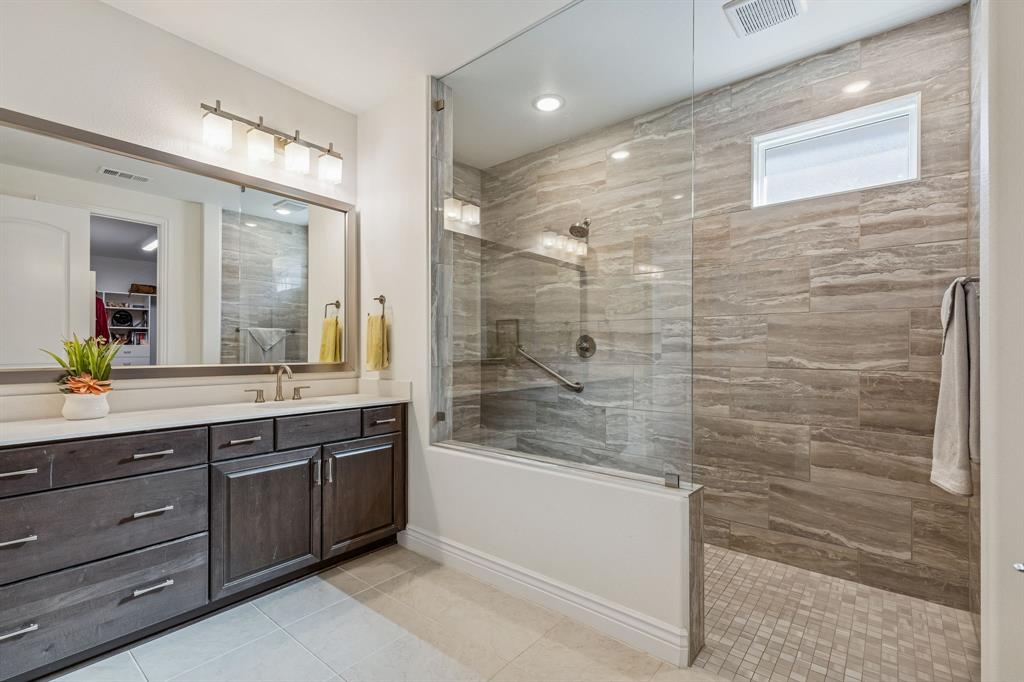 8717 Basanite Avenue Denton, TX 76207 - Photo 18 of 30 a bathroom with a granite countertop sink mirror and shower