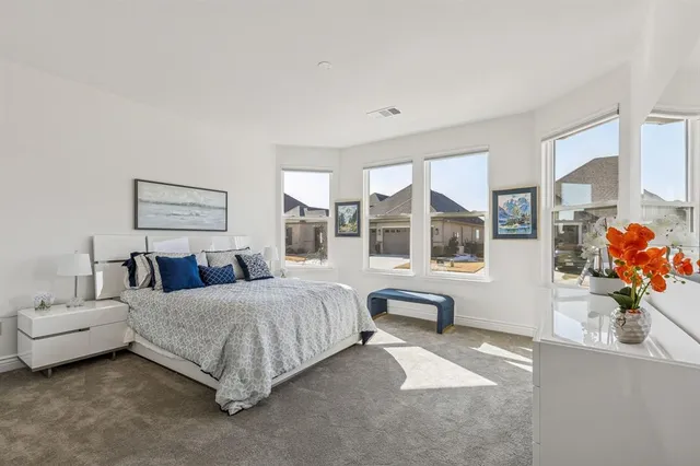 a bedroom with a white bed and a large mirror