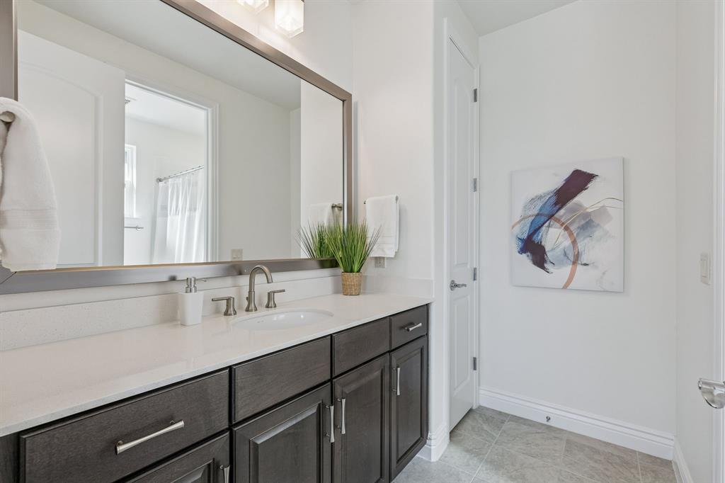 8717 Basanite Avenue Denton, TX 76207 - Photo 25 of 30 a bathroom with a sink and a mirror
