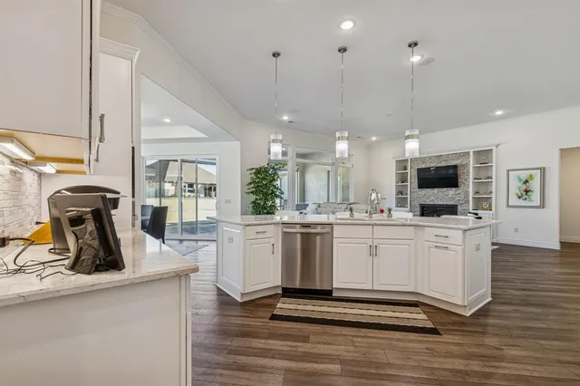 a kitchen with stainless steel appliances granite countertop a sink and a refrigerator