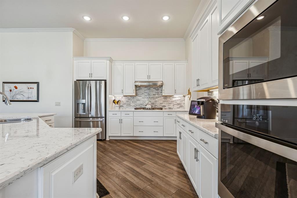 8717 Basanite Avenue Denton, TX 76207 - Photo 9 of 30 a kitchen with stainless steel appliances granite countertop a sink stove and refrigerator