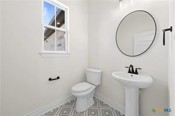 a bathroom with a toilet a sink and a mirror