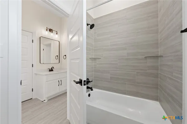 a bathroom with a bathtub shower and a sink