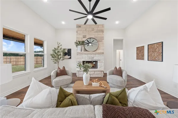 a living room with fireplace furniture and a large window