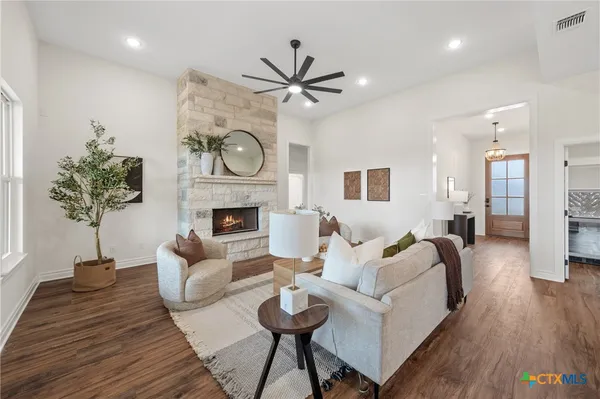 a living room with furniture a fireplace and a potted plant