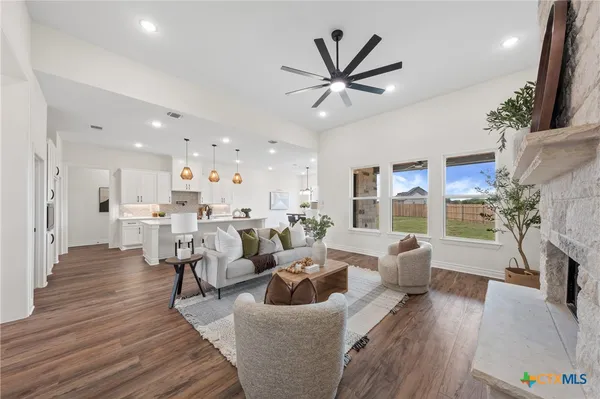 a living room with fireplace furniture and a wooden floor