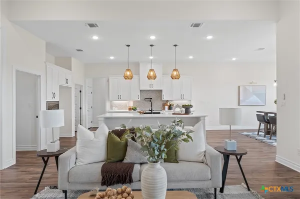 a living room with furniture and kitchen view
