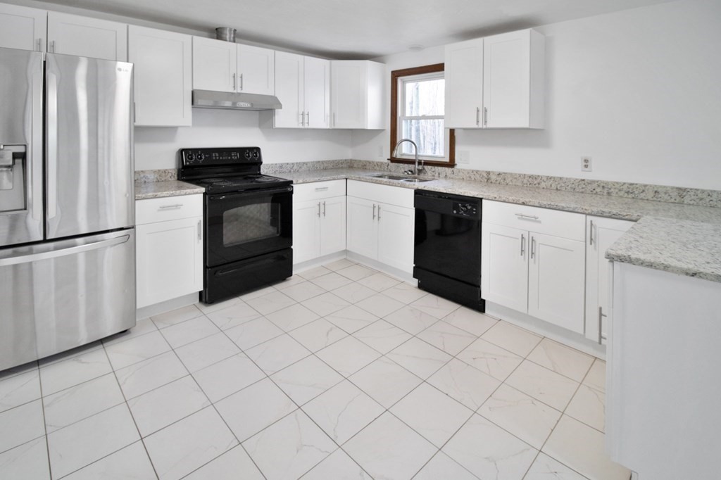 3 Colonial Road Sutton, MA 01590 - Photo 3 of 26 a kitchen with white cabinets stainless steel appliances and a refrigerator