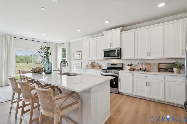 a kitchen with stainless steel appliances kitchen island granite countertop a sink stove and cabinets