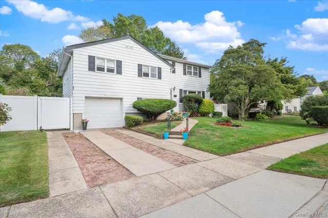 a front view of a house with a yard and potted plants