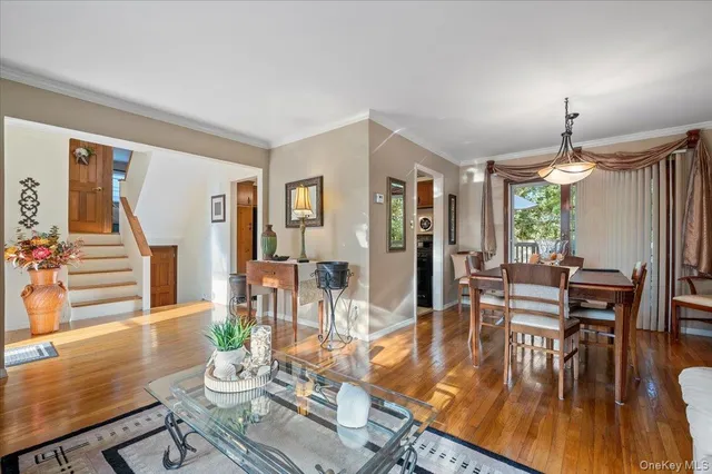 a dining room with wooden floor a chandelier a glass table and chairs