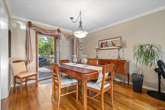 a dining room with furniture a chandelier and wooden floor