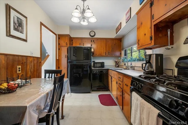 a kitchen with stainless steel appliances granite countertop a stove top oven a sink a dining table and chairs