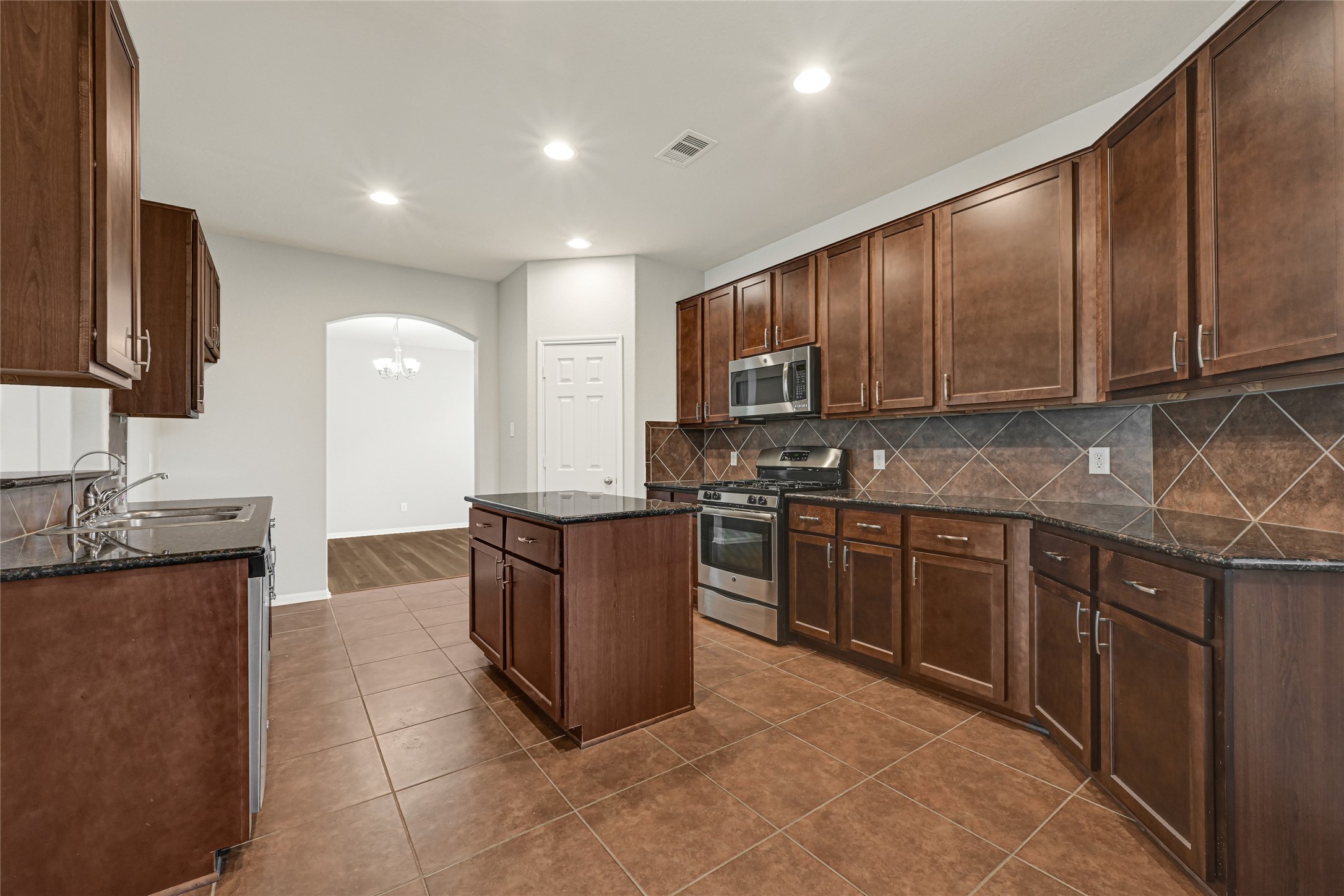 5331 Seabird Street Baytown, TX 77521 - Photo 18 of 38 a kitchen with stainless steel appliances granite countertop a sink stove and refrigerator