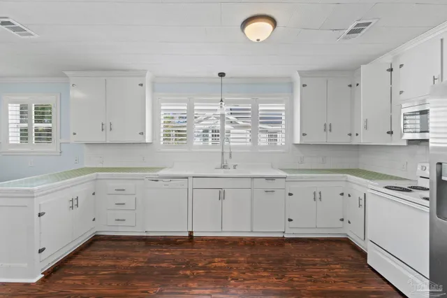 a kitchen with granite countertop white cabinets and white appliances